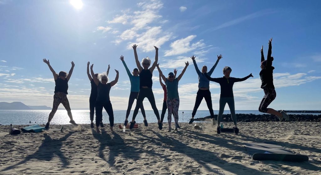 a large group of people doing a starjump on the beach